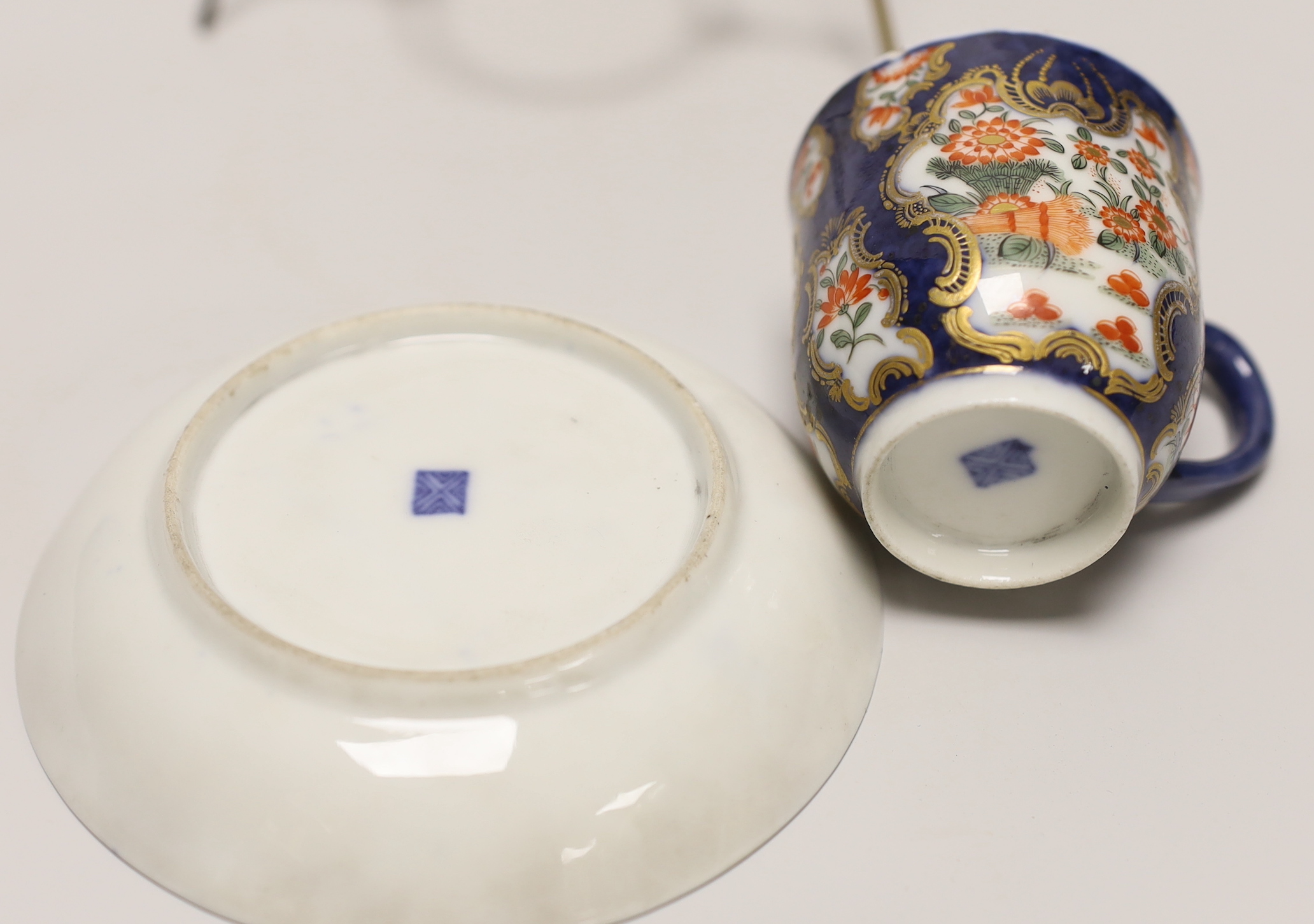 A Samson replica of a Worcester scale blue cup and saucer, hand painted with flowers on stand, the saucer 12cm in diameter
